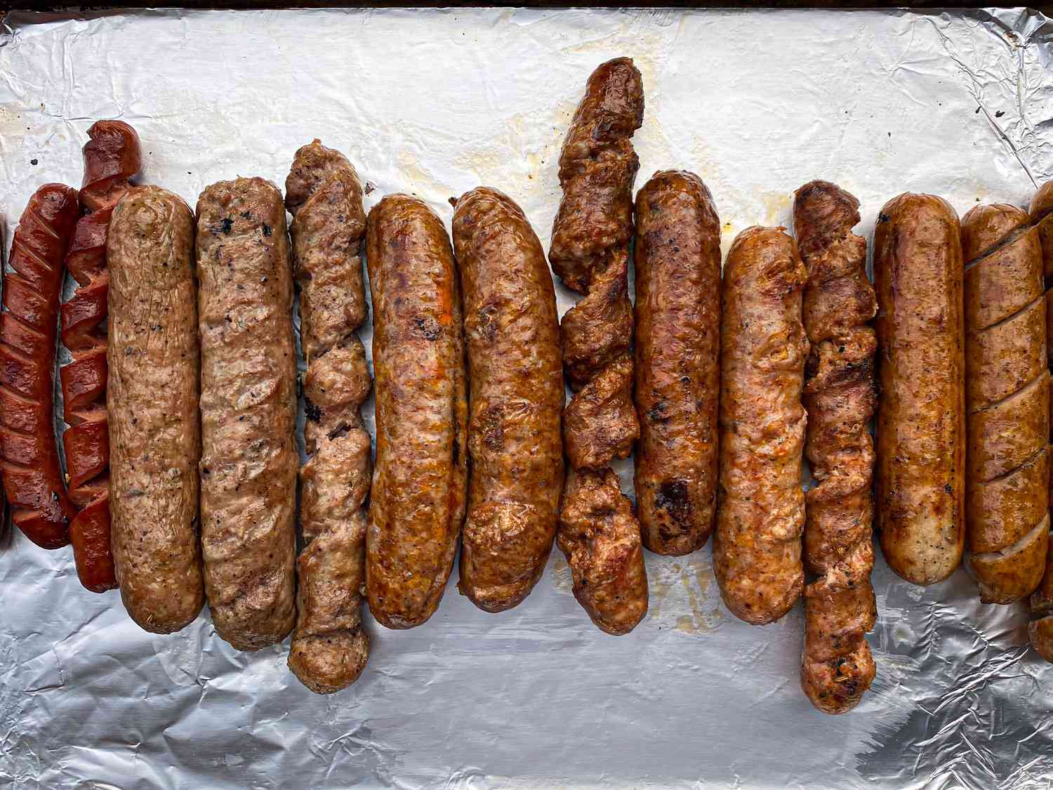 A line up of sausages grilled with different methods. 