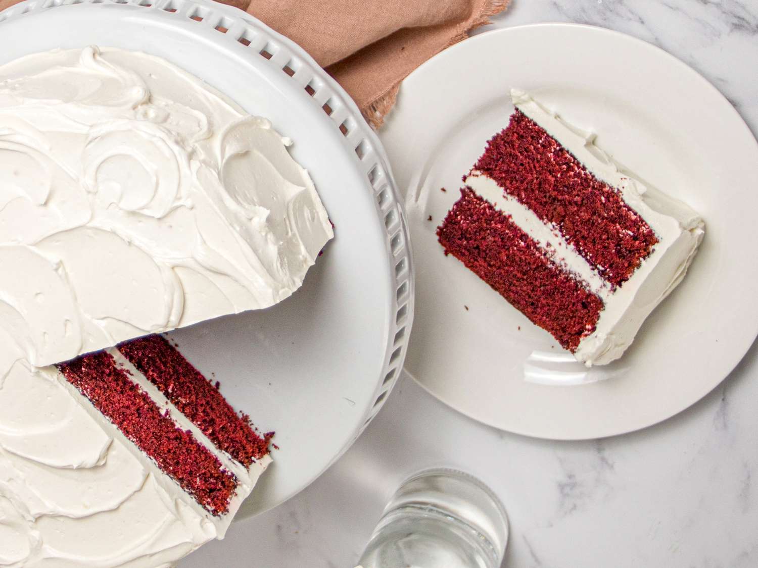 Overhead view of a slice of red velvet layer cake plated