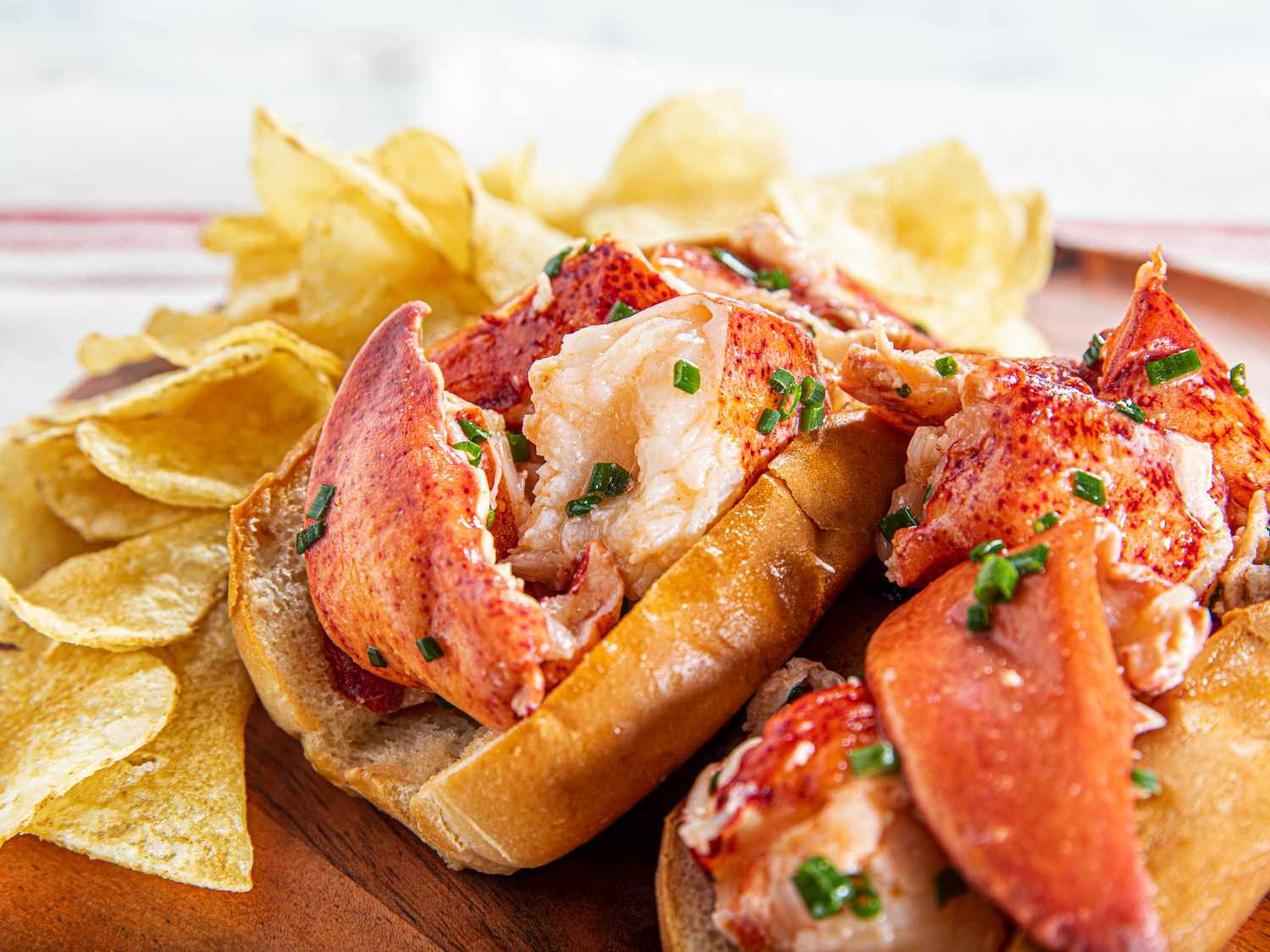 Two lobster rolls overflowing with lobster