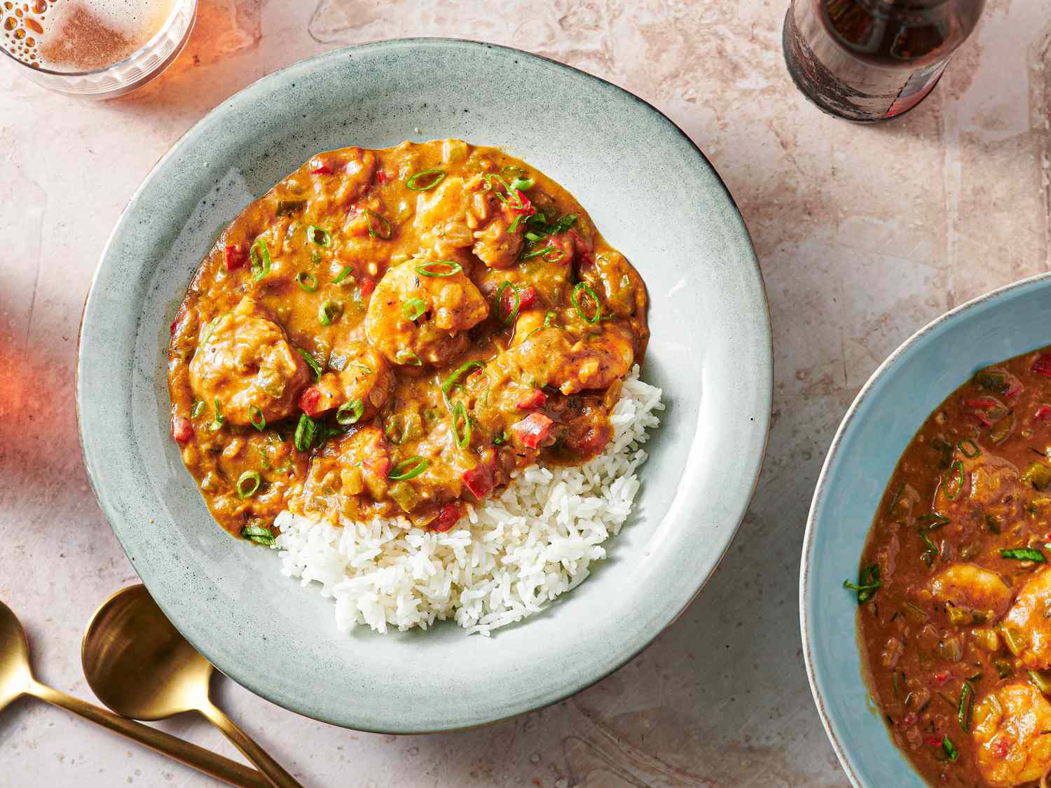 Shrimp étouffée in a soup plate with rice and thinly sliced scallions