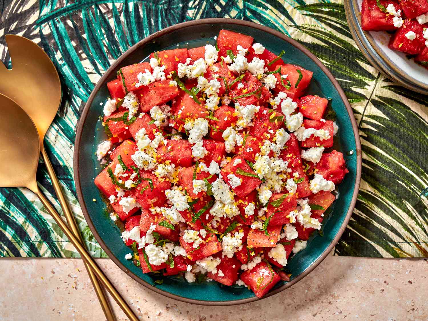 Watermelon, feta, and mint salad in a bowl on a colorful tropical print napkin