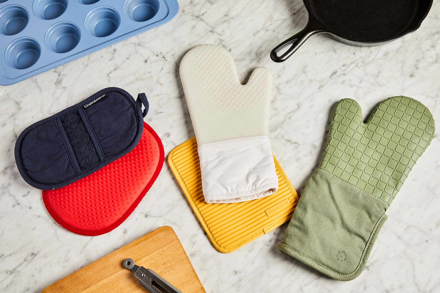 oven mitts and pot holders on a marble surface