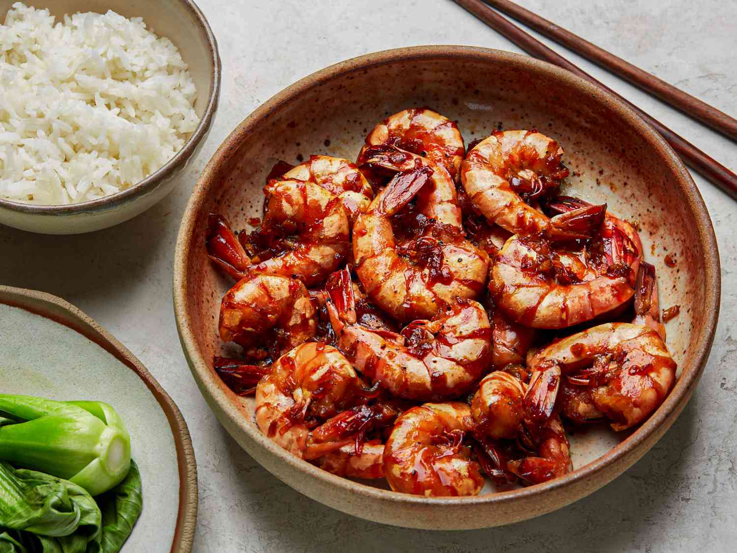 Overhead view of braised shrimp with a side of rice and bok choy 