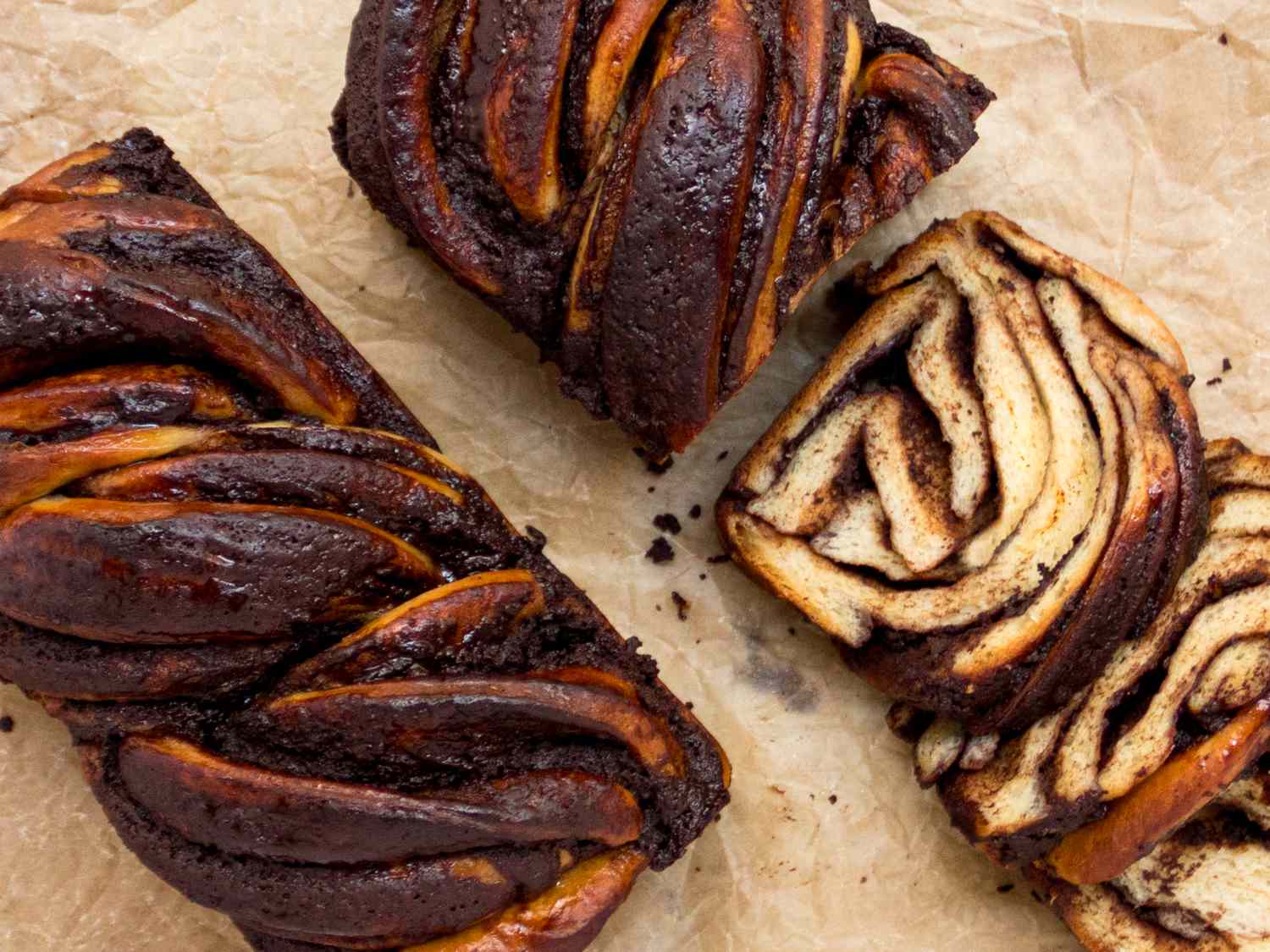 2 babkas on a parchment paper, one sliced and one whole