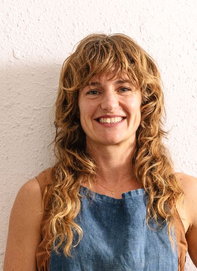 A portrait of Serious Eats contributor Jennifer Latham standing in front of a white stucco wall.