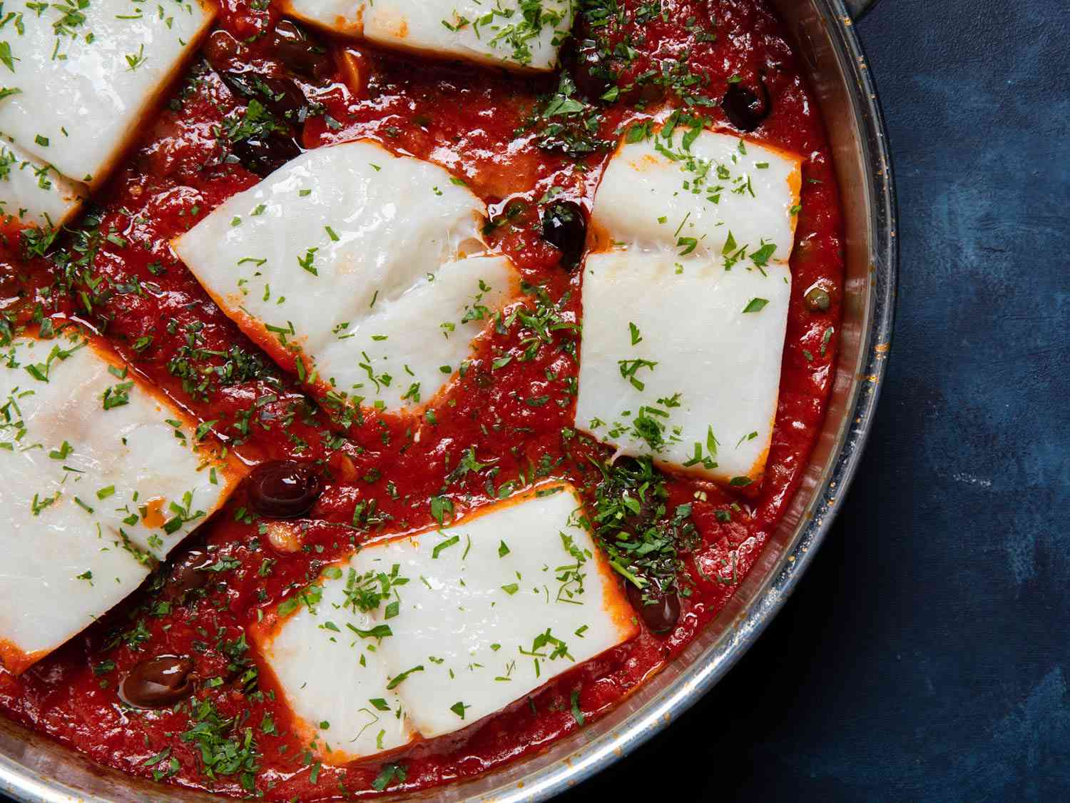 Closeup overhead of a skillet of baccalÃ  alla napoletana.