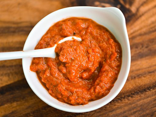 A small white bowl of ajvar, Serbian roasted red pepper sauce.