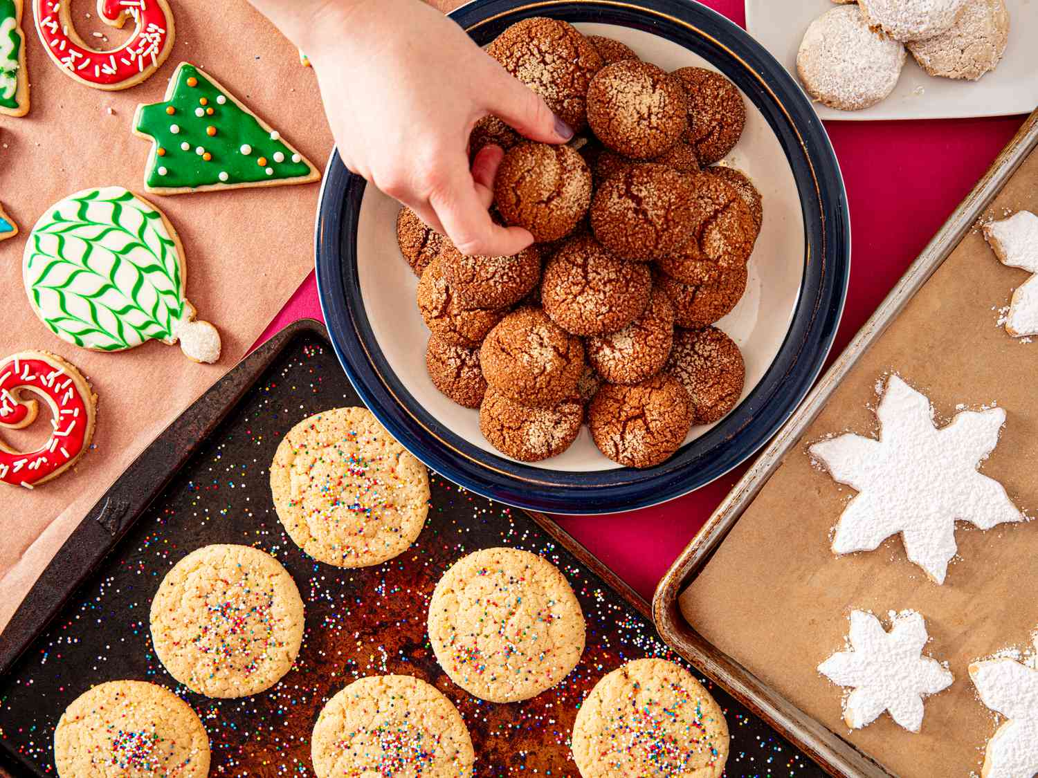 Overhead view of a hand reaching to grab many cookies