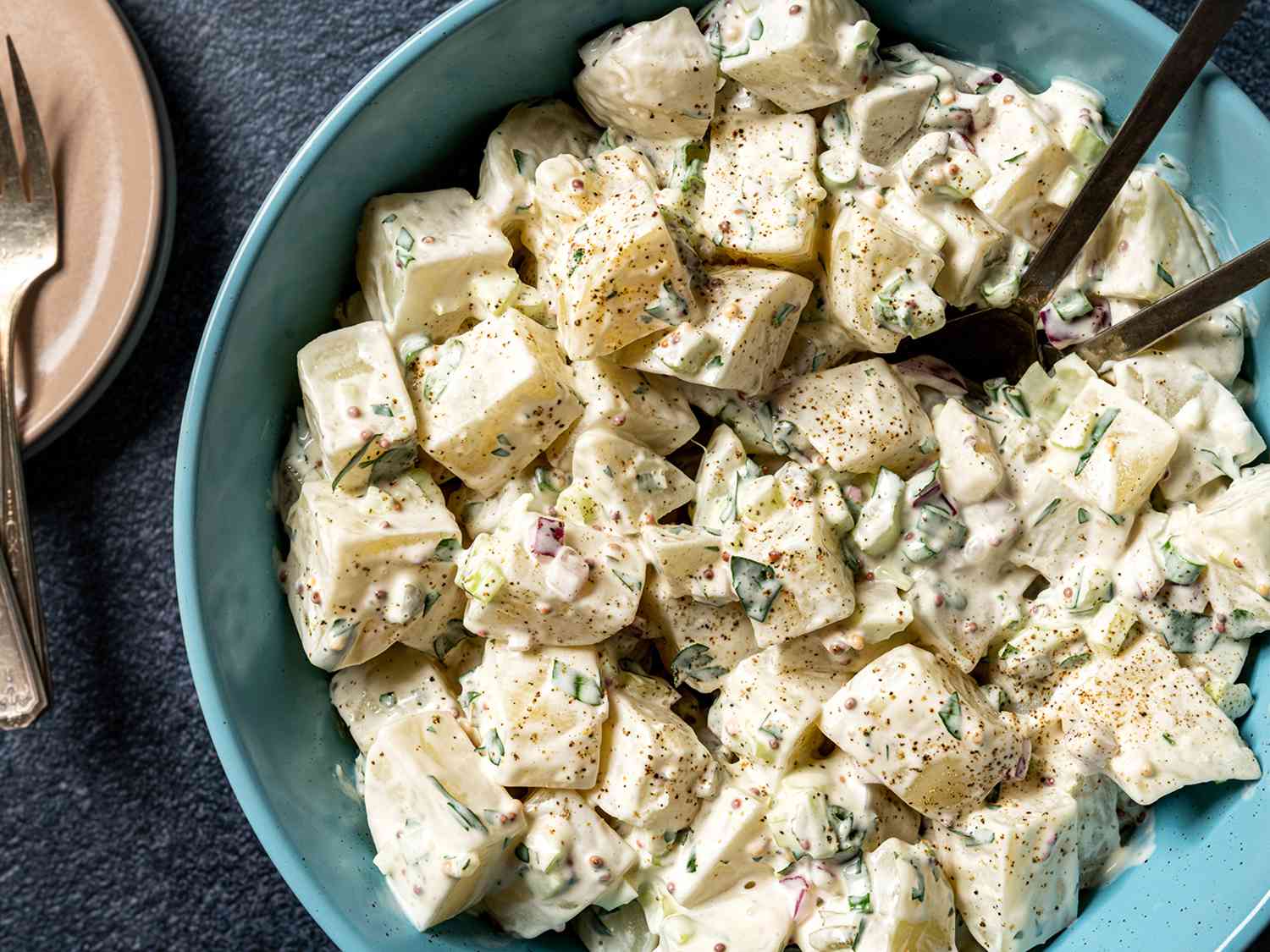 Overhead view of classic potato salad served in a light blue bowl.