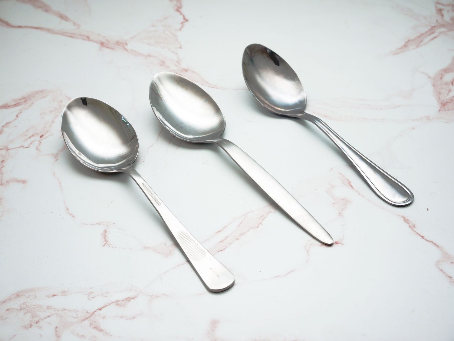 Sauce spoons on a pale pink marble countertop