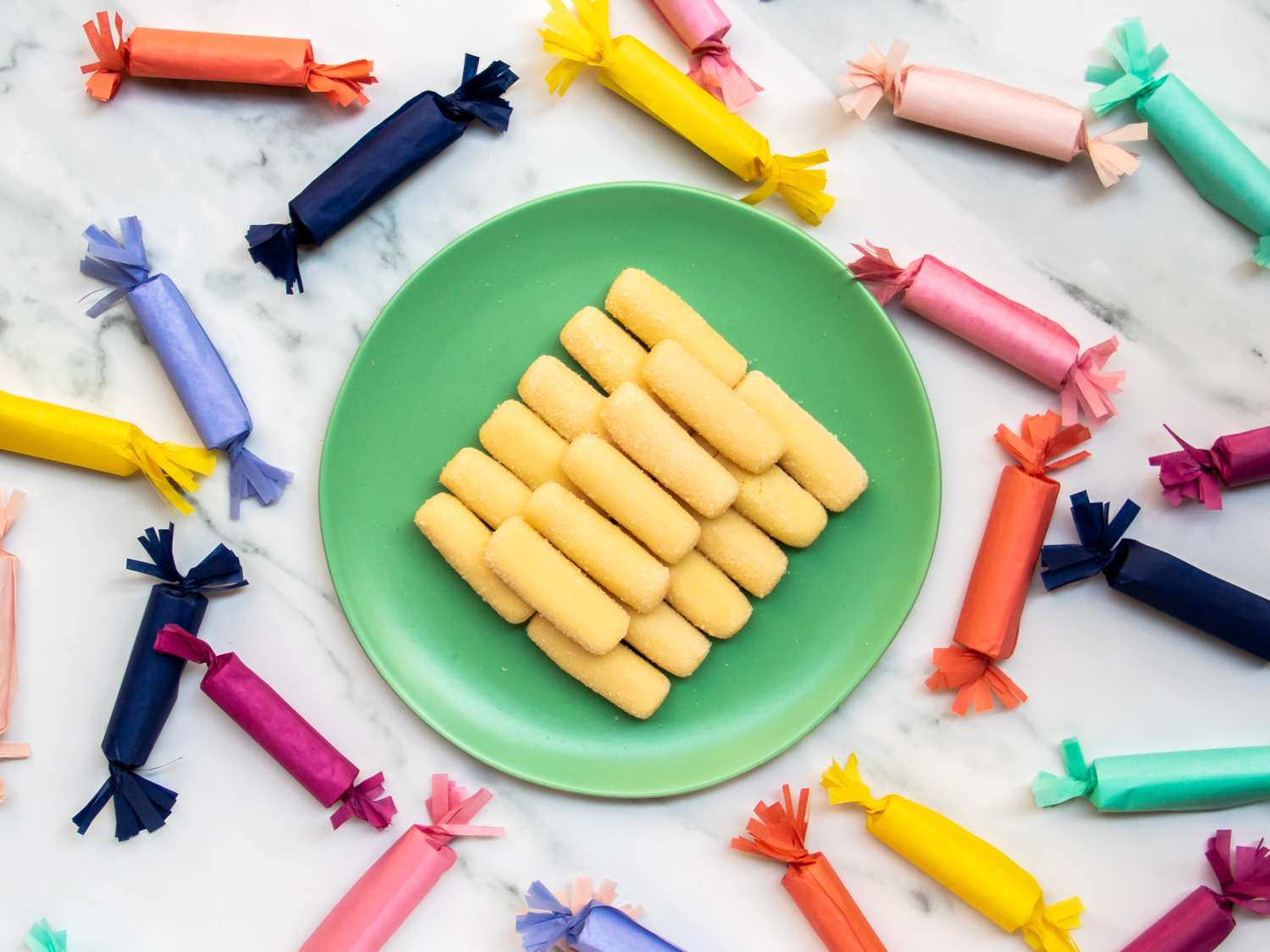 a plate of pastillas de leche surrounded by more candy in wrappers