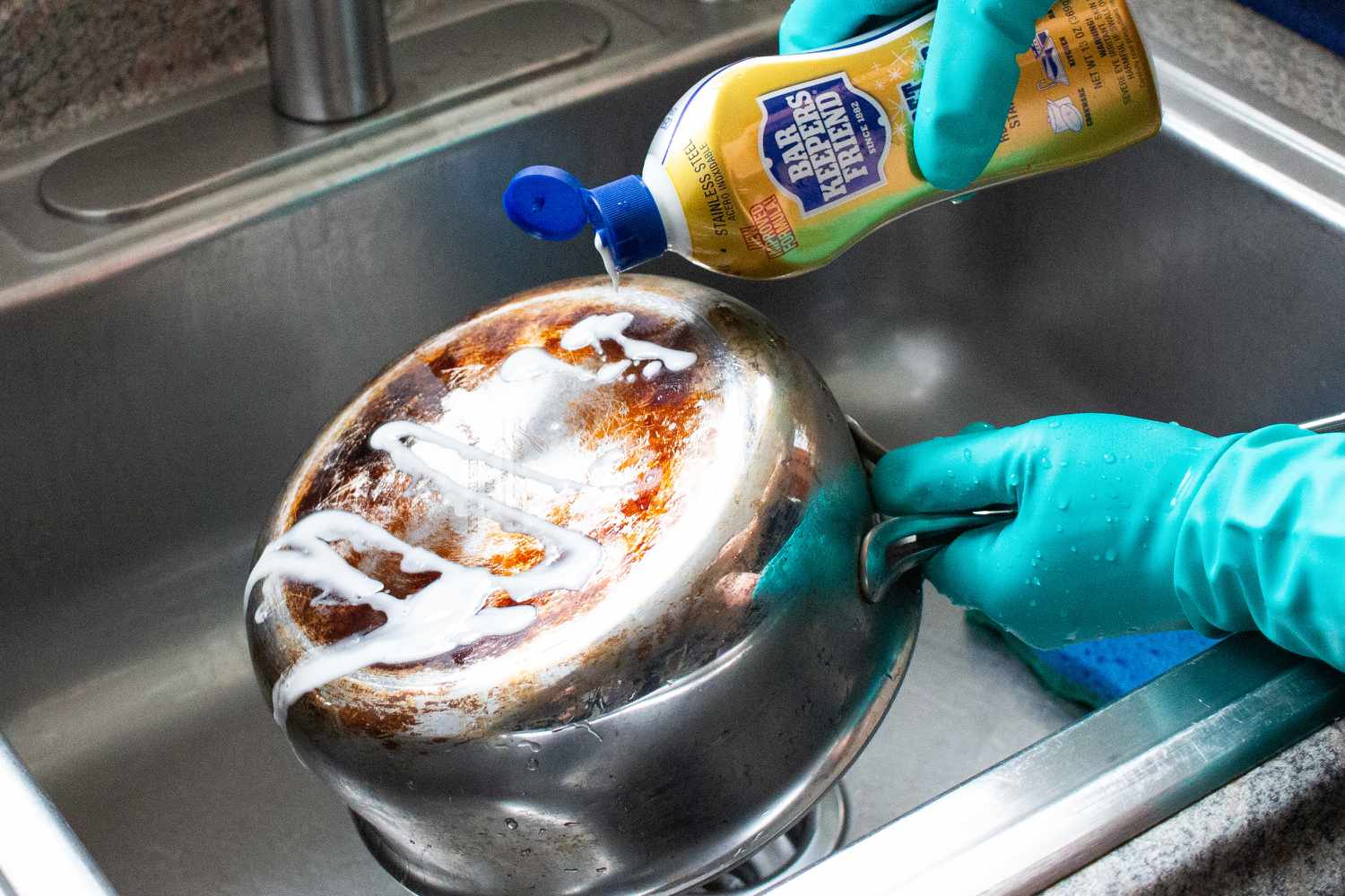 A person cleaning a pan with Bar Keeper's Friend.