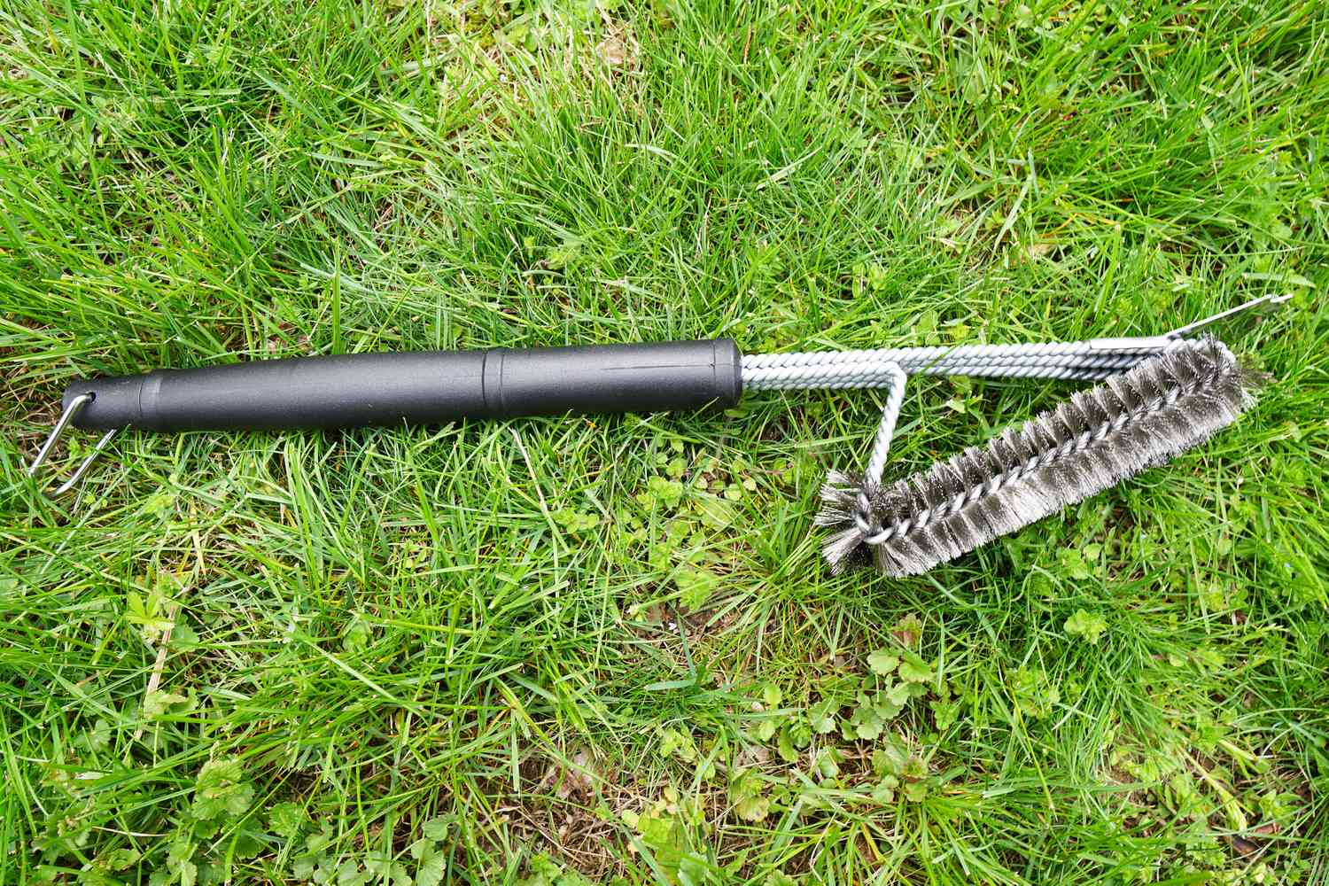 a grill brush on a grassy surface