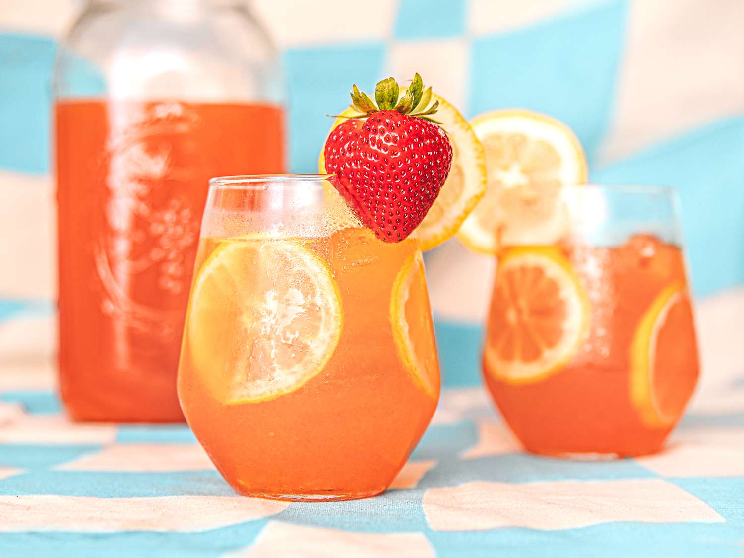 Strawberry lemonade in two glasses and a pitcher