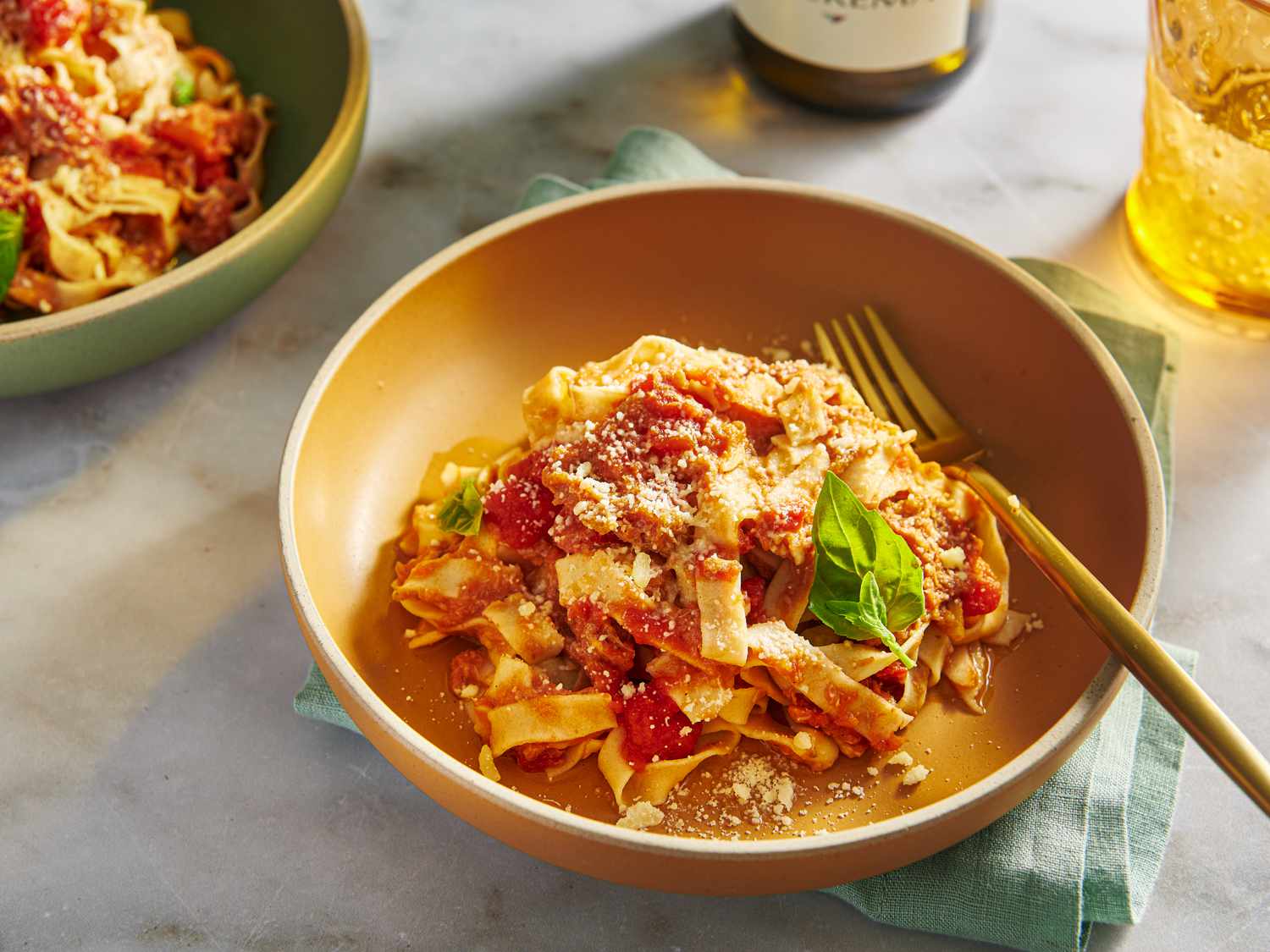 A bowl of homemade gluten-free fresh pasta with tomato sauce in an orange bowl.