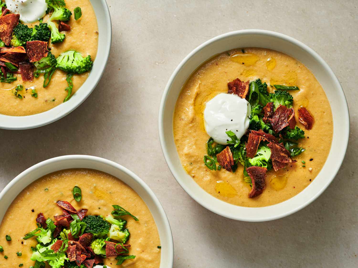 Three bowls of fully loaded vegan baked potato soup