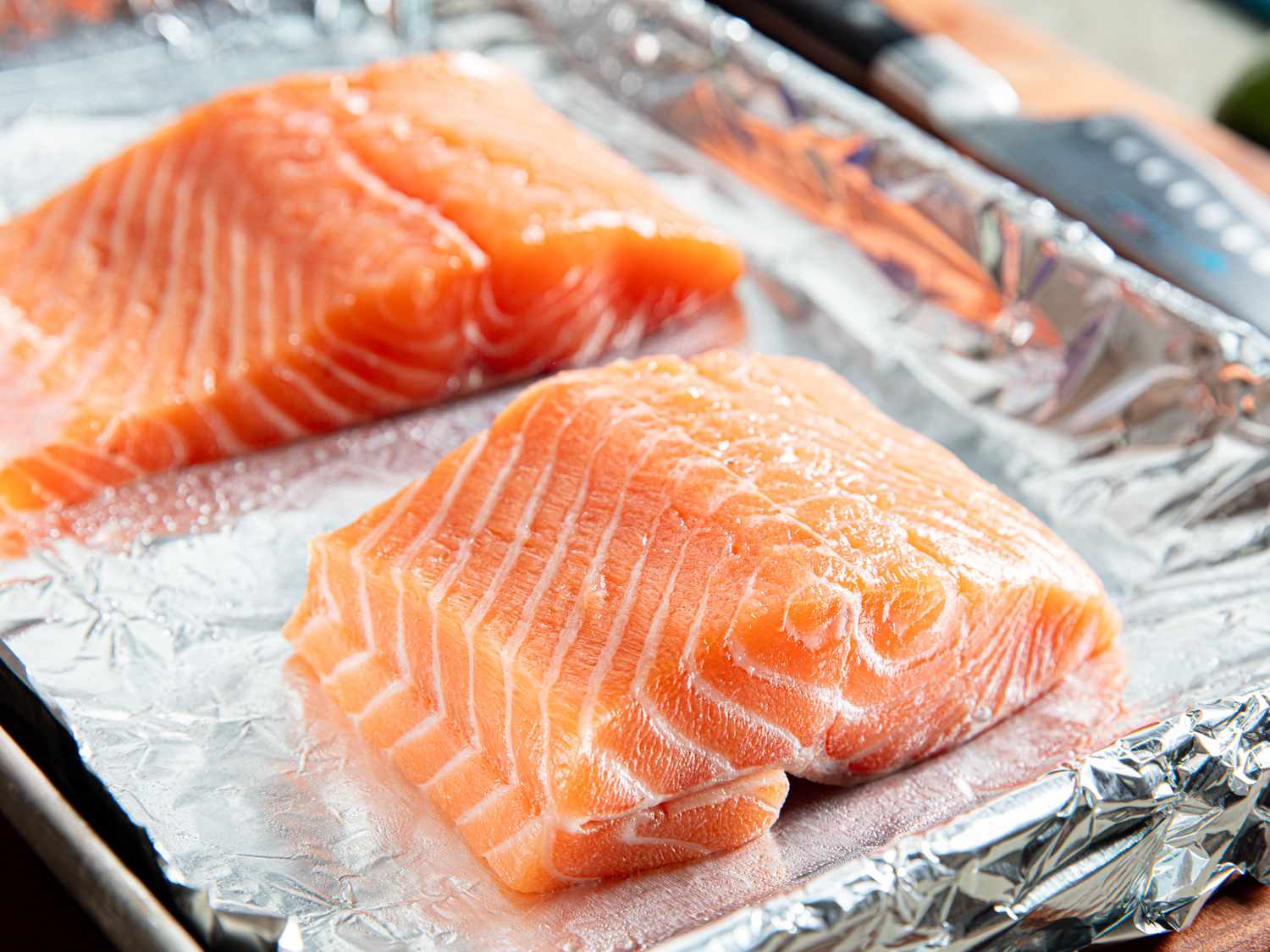 Salmon on a foil-lined sheet tray.