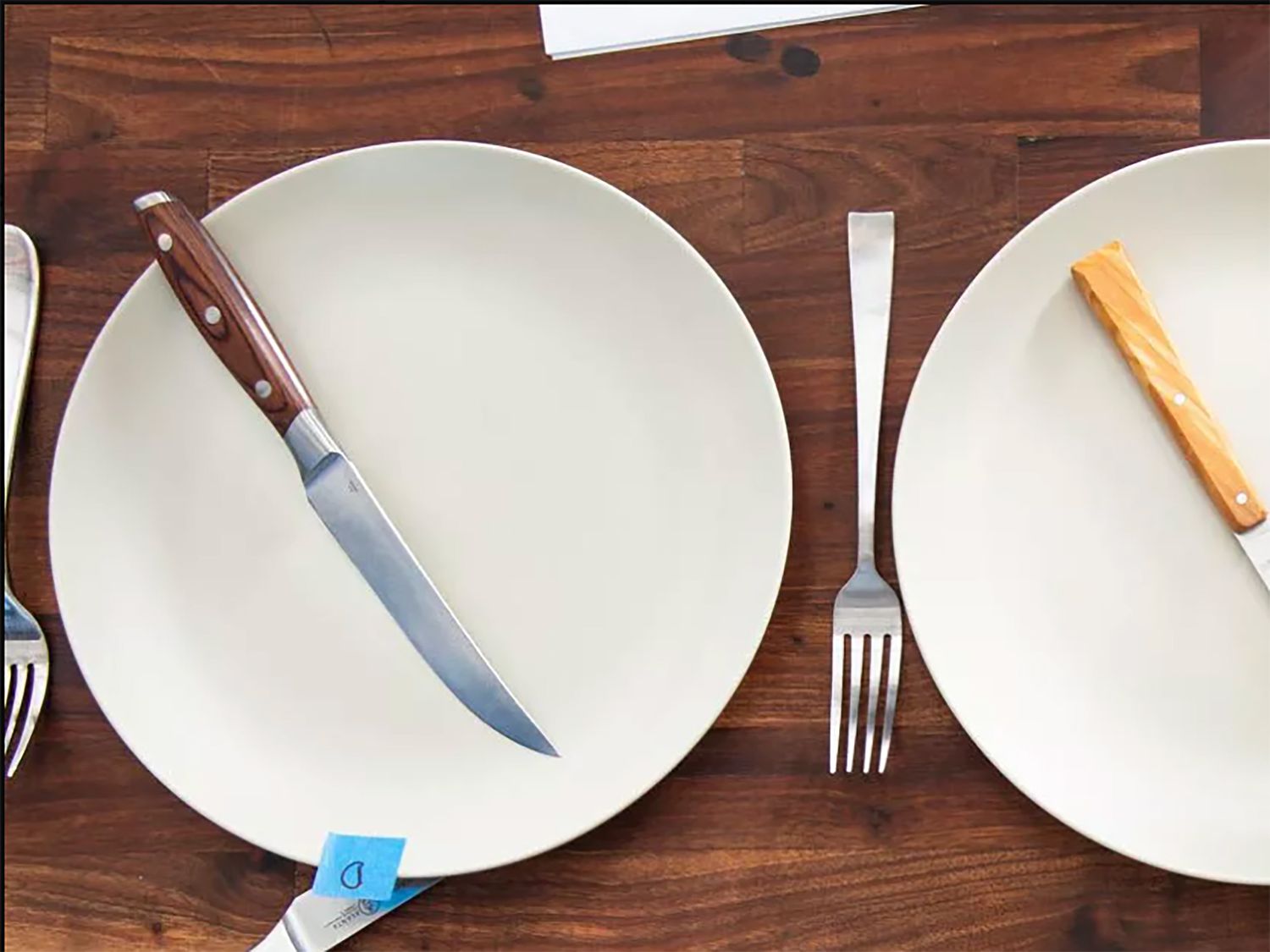 a closeup image of the messermeister knife on a plate with another knife and plate next to it