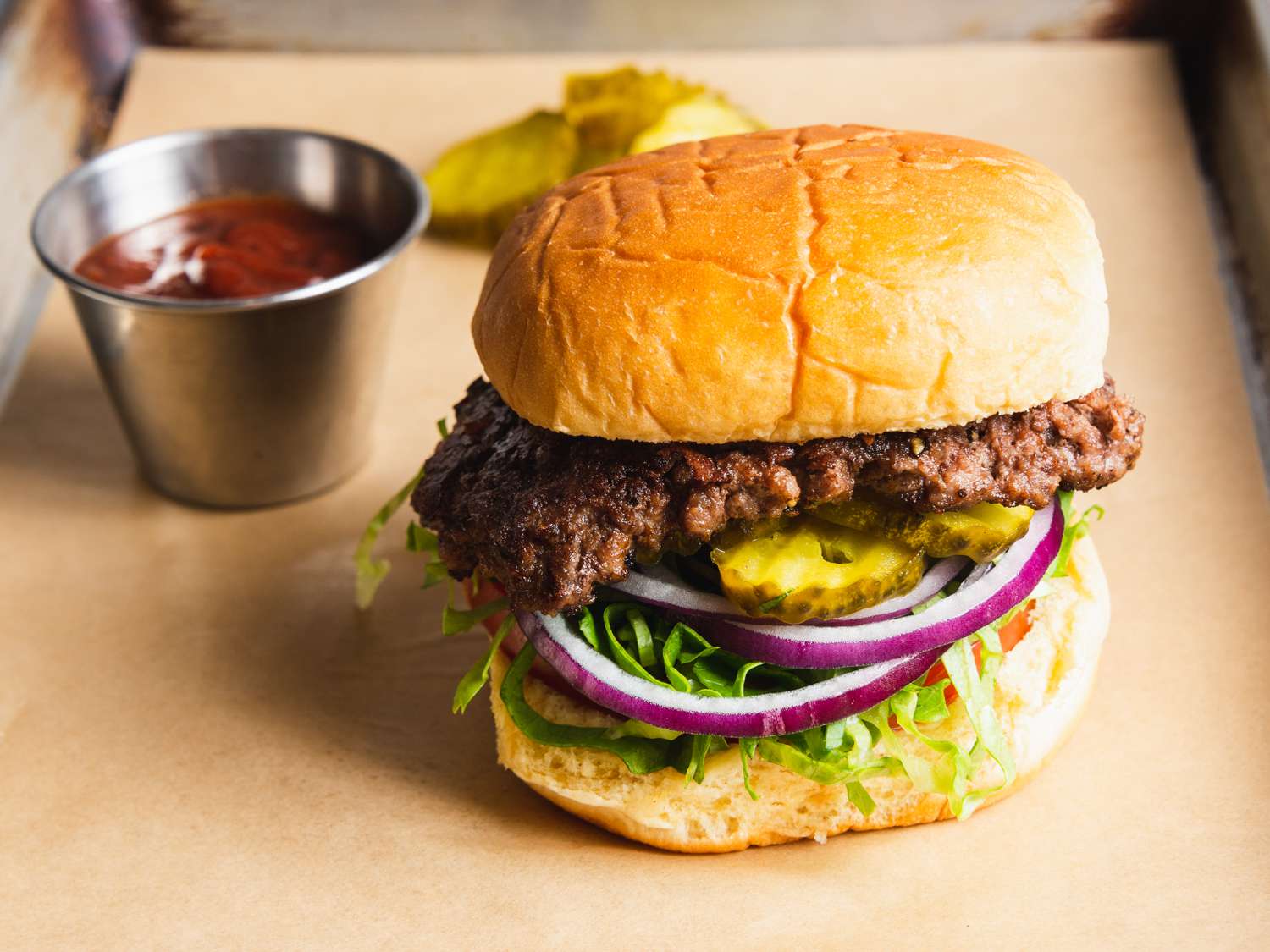 a classic smashburger with pickles and ketchup on the size