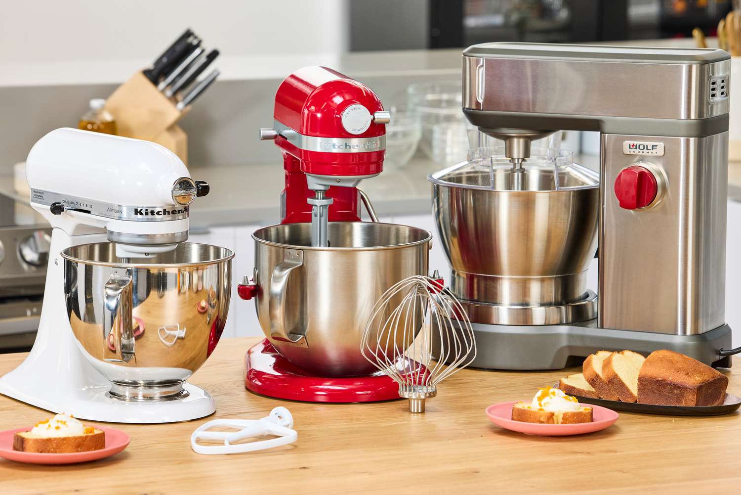 Three stand mixers on a kitchen countertop.