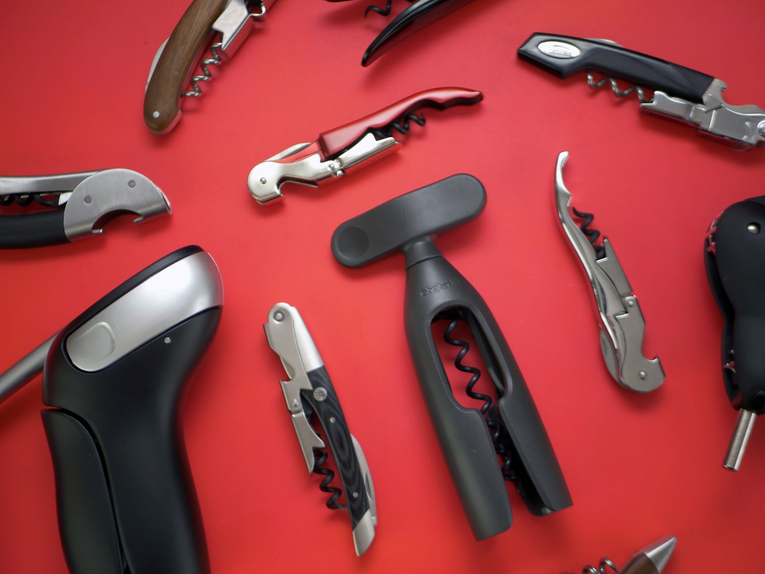 assorted wine openers on a red background