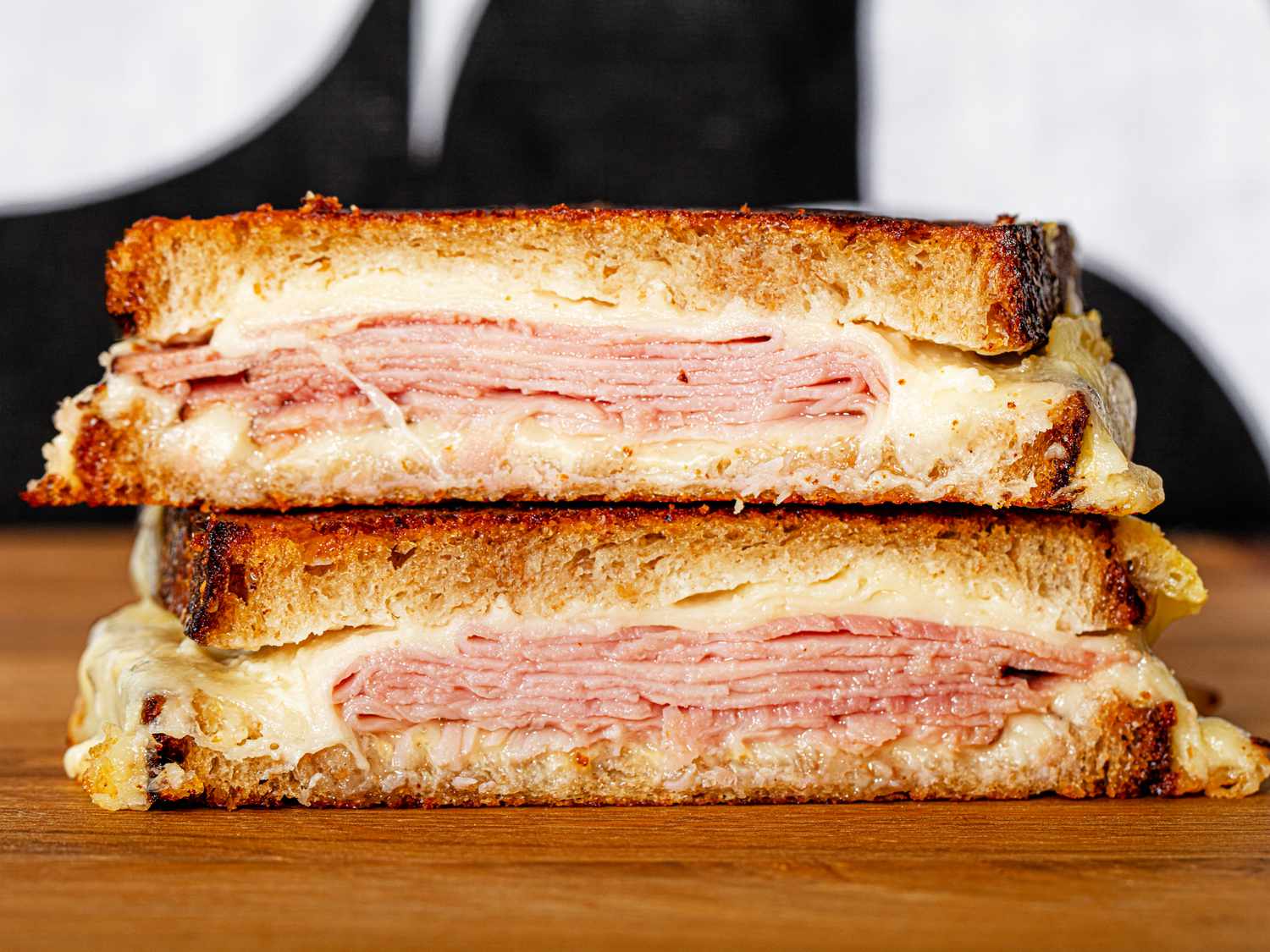 A view of a split ham and cheese sandwich stacked on top of one another.