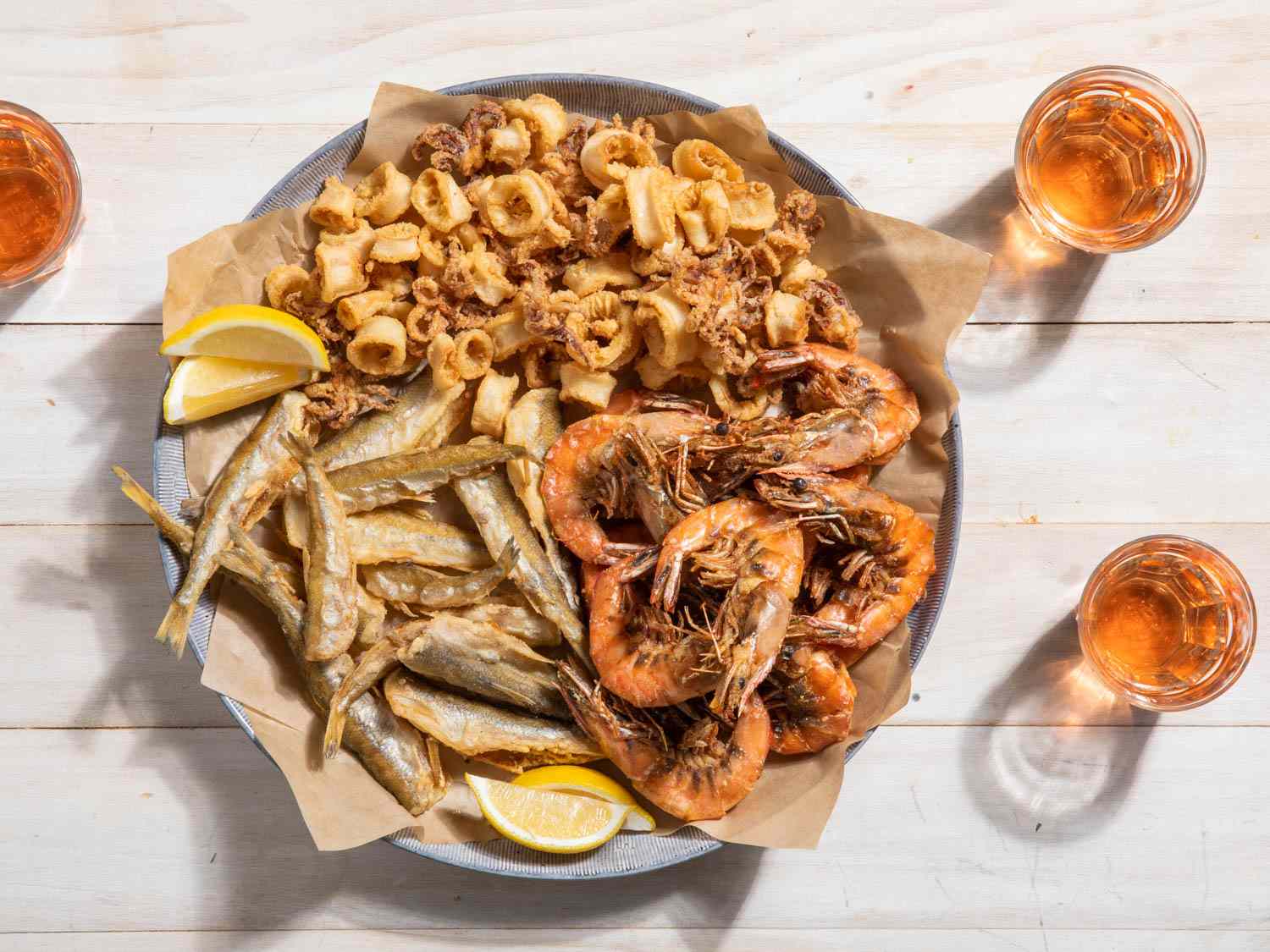 A large platter of fritto misto di mare with fried shrimp, squid, and smelt.