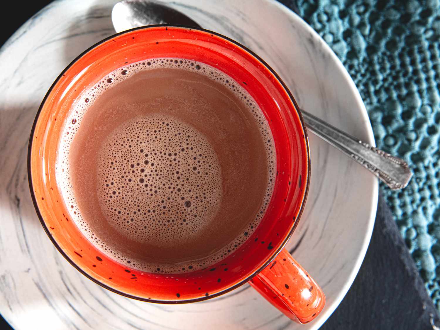 Overhead shot of a red mug containing hot chocolate.