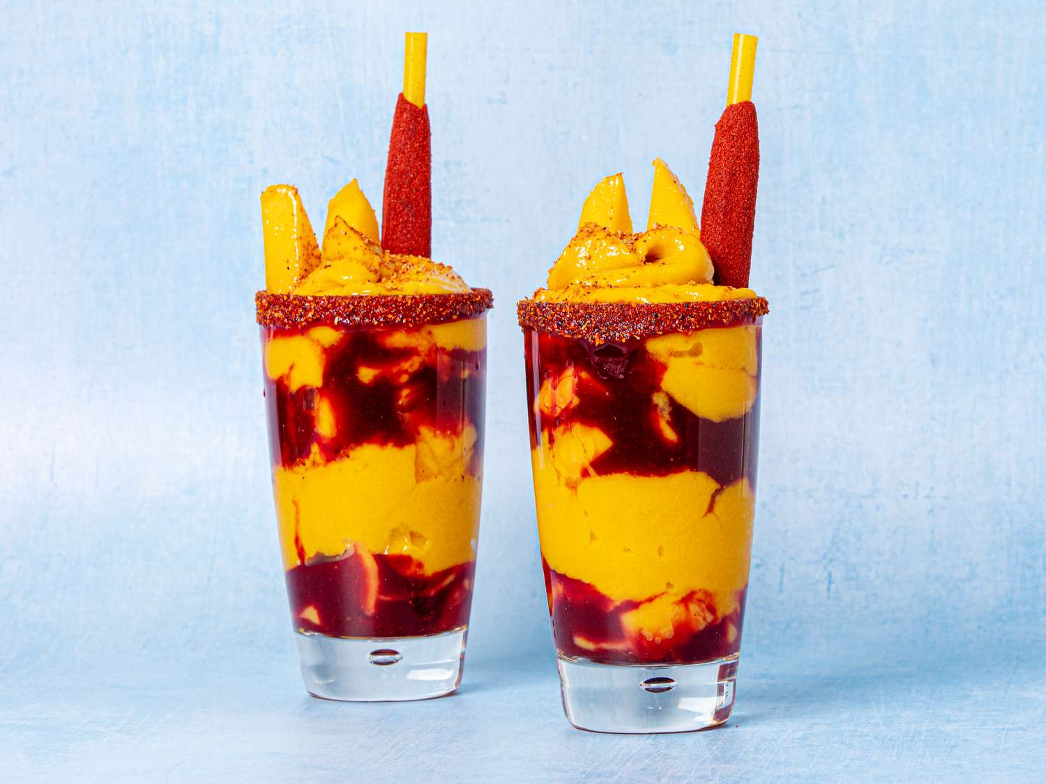 Two Mangonadas on a textured blue background