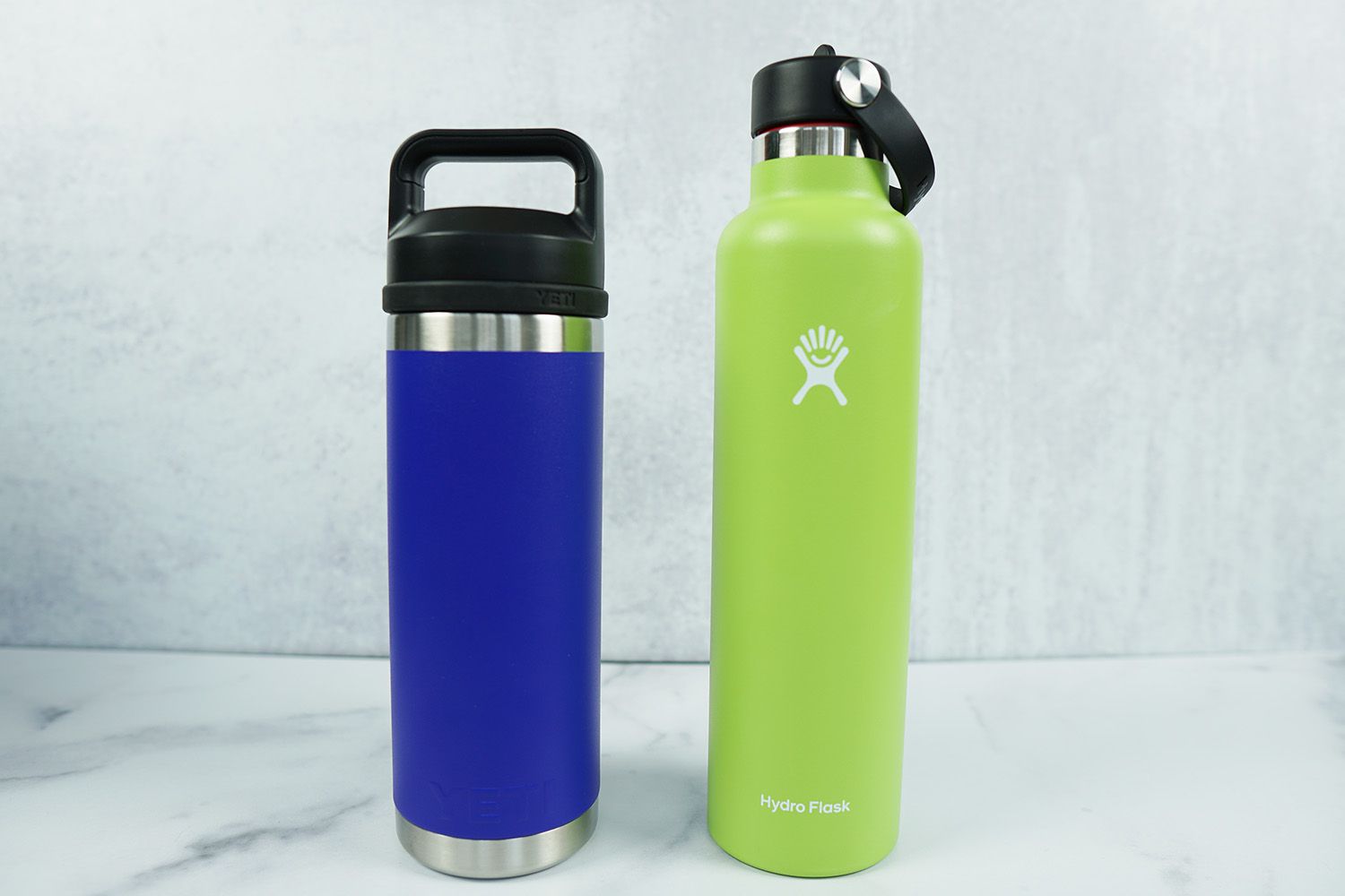 a HydroFlask and a Yeti water bottle side-by-side on a marble surface