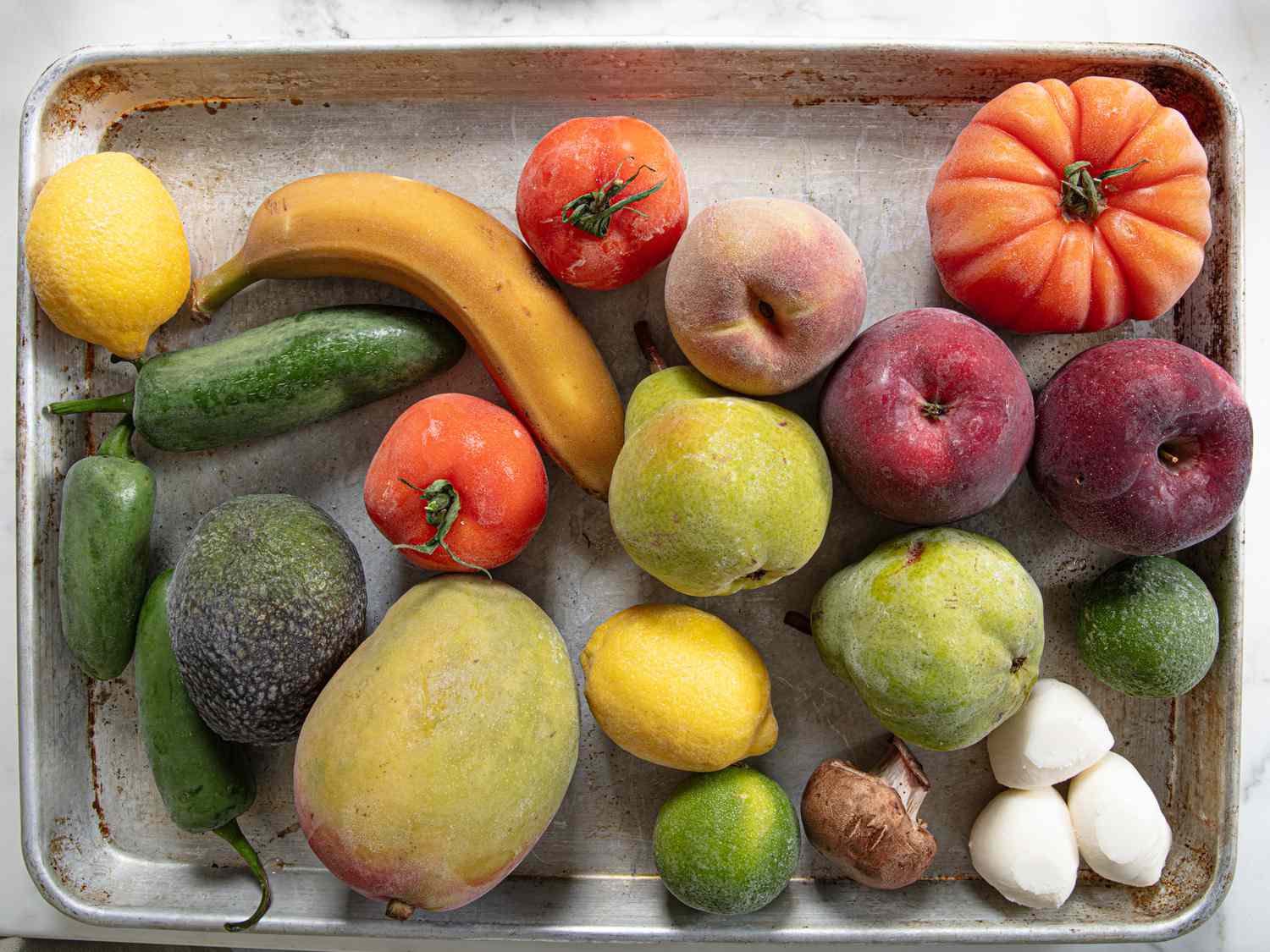 A sheet pan with frozen fruits and vegetables