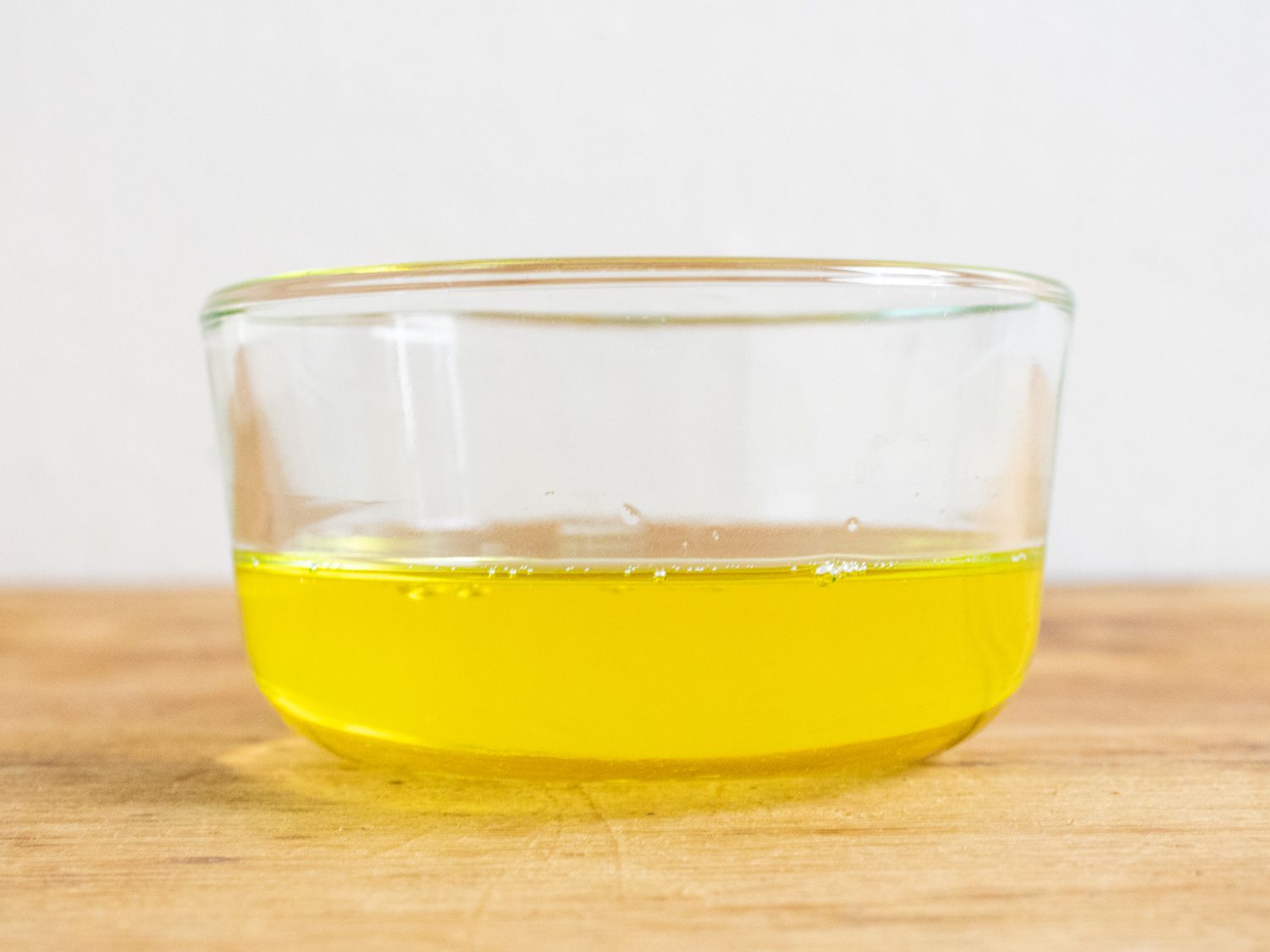 A small glass bowl of golden chicken fat