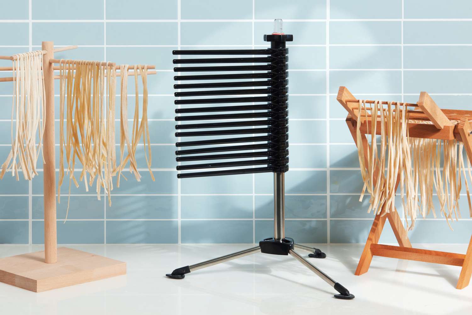 three pasta drying racks on a kitchen countertop