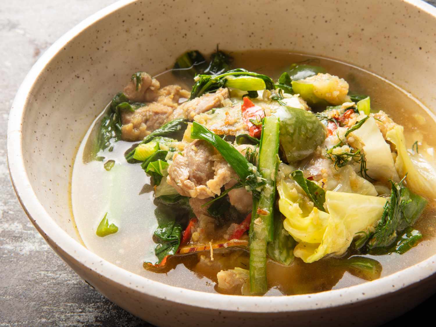 a close up of Gaeng Om Gai (Isan-Style Herbal Curry with Chicken and Dill) in a bowl