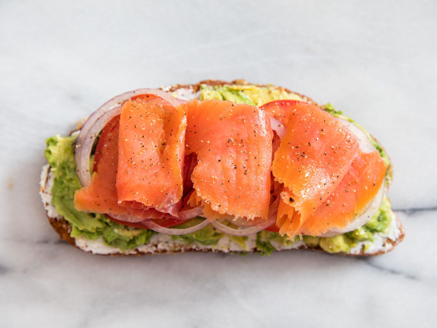 A top-down shot of the avocado toast topped with smoked salmon.