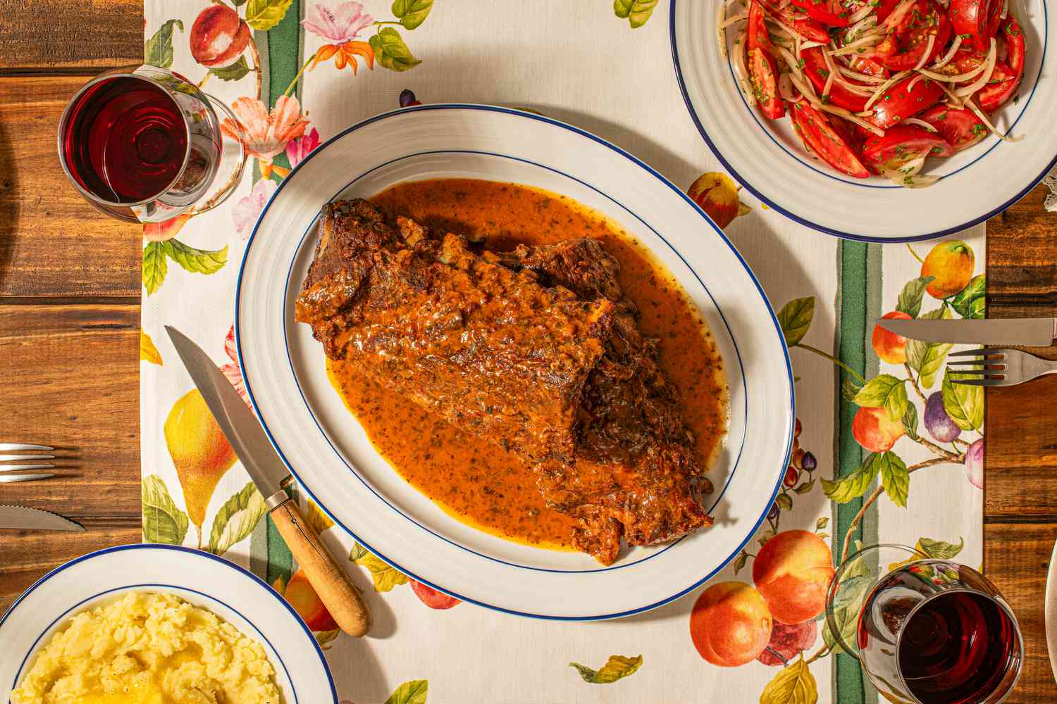 Overhead view of Costillar a la Chilena on a fruit patterened table runner