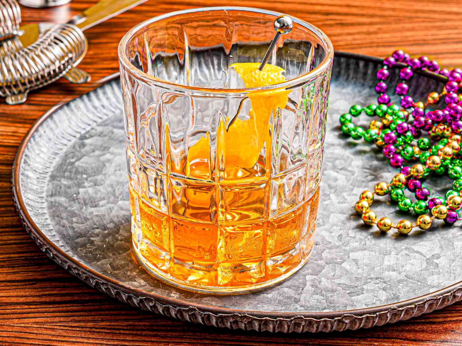 Overhead view of a Sazerac with Mardi Gras beads