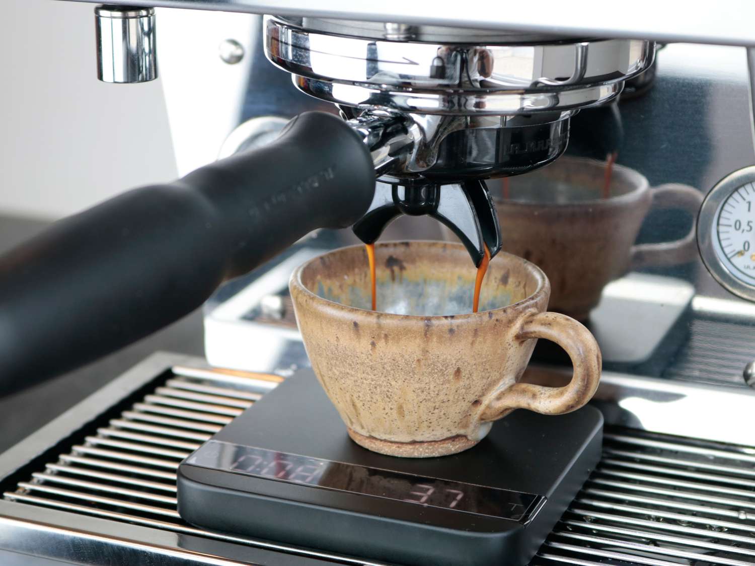 Espresso dripping into a mug from an espresso machine