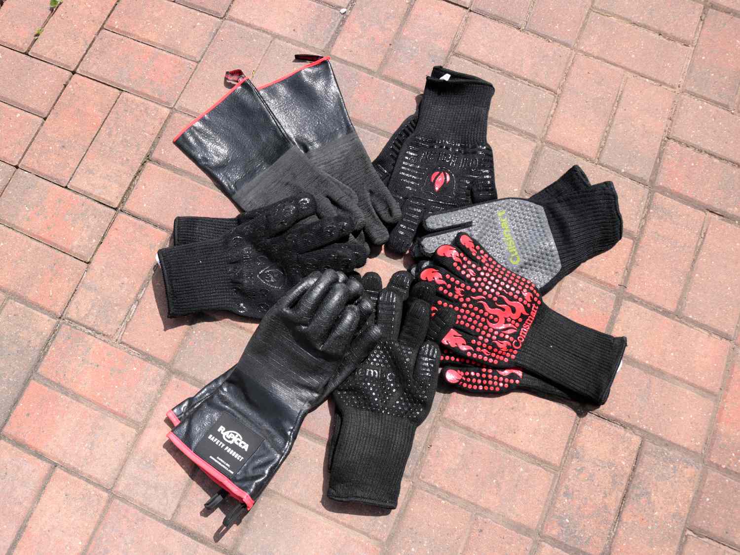 a pile of grill gloves in a circle against a brick background